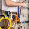 A person is holding a heavy-duty tool belt with various tools and a hook/holster for cordless drills.