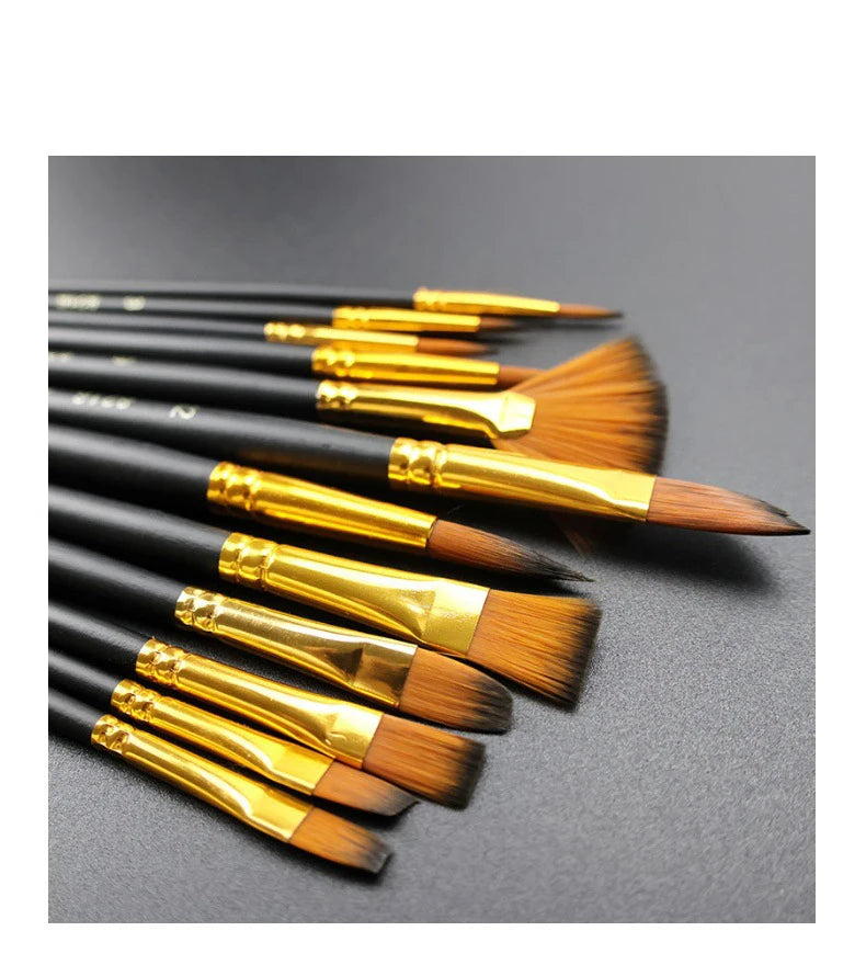 A set of twelve black nylon flat painting brushes with gold ferrules arranged diagonally on a dark surface.
