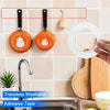 Orange silicone mounting tape and adhesive tape hanging on a tiled wall next to a kitchen sink.