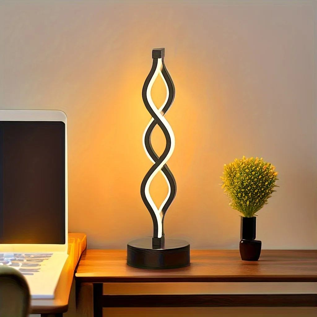 A modern desk lamp with a glowing, wavy light design illuminates a workspace.