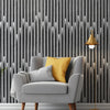A gray armchair with a yellow cushion is placed in front of a dark wood slat wall and a gold floor lamp.