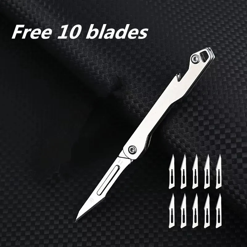 A silver mini folding art knife with ten replacement blades displayed on a black textured background.