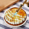 A professional gas torch is used to caramelize the top of a dessert, creating a golden-brown effect.
