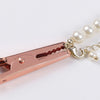 A rose gold precision jewelry clasp helper tool with a pearl chain attached.