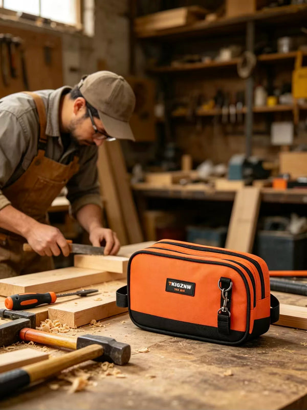 Una bolsa de herramientas naranja sobre un banco de trabajo de madera rodeada de varias herramientas manuales.