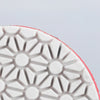 Close-up view of a white polishing disc with a geometric pattern on the sole.