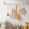 A set of ten wooden and mesh kitchen utensils hanging from a white bar in a kitchen