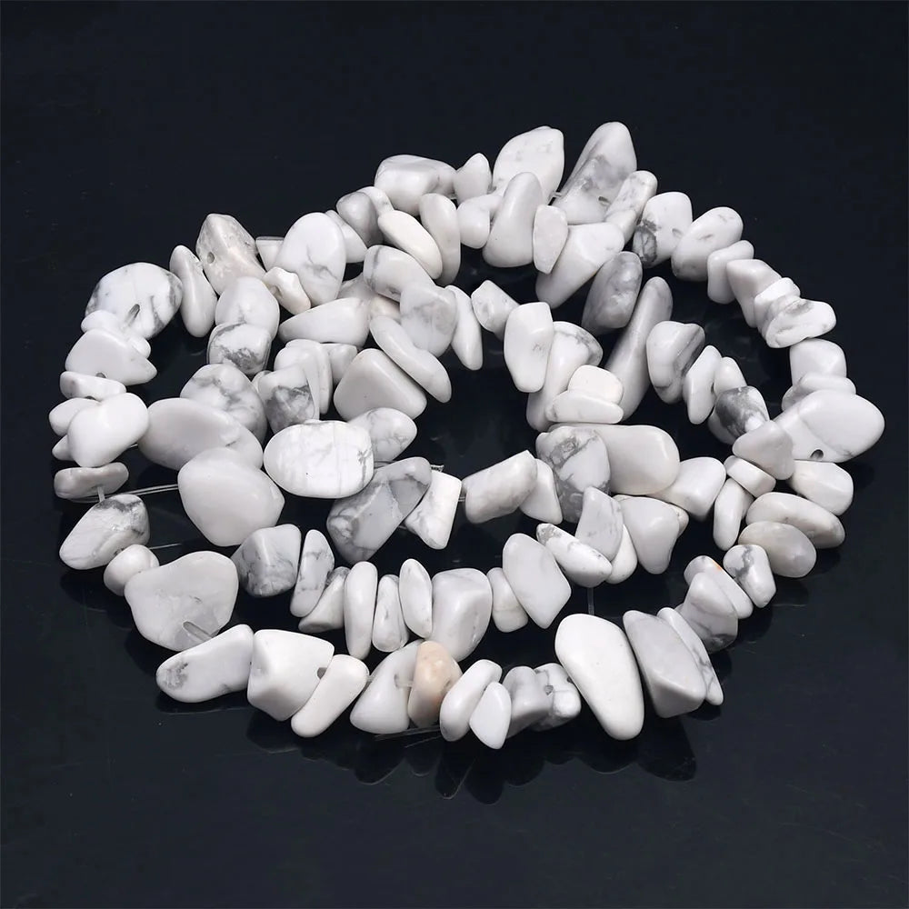 A collection of white and gray natural agate beads arranged in a circular pattern.