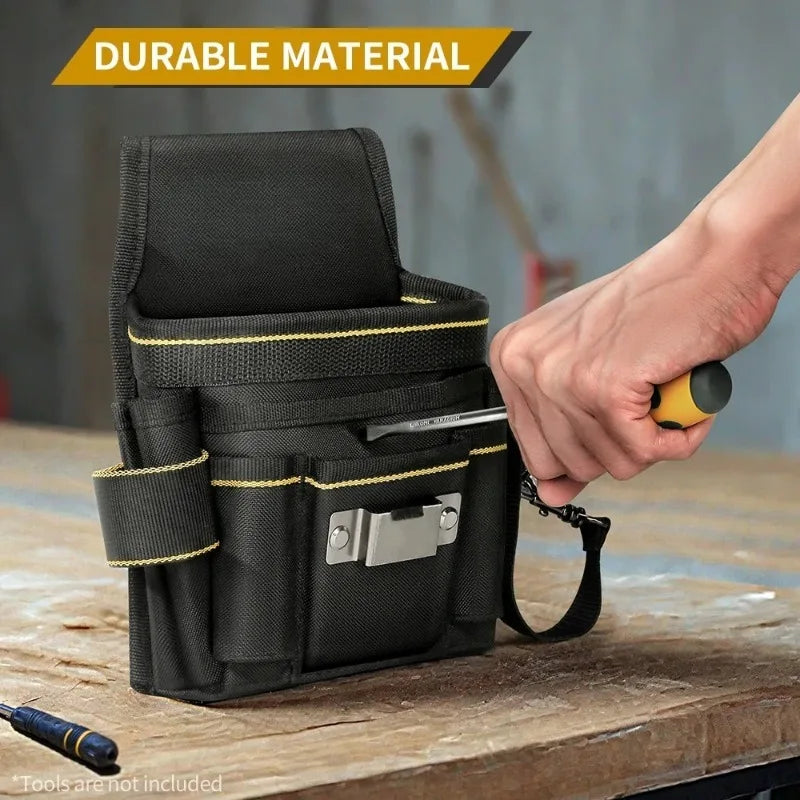 Una bolsa de herramientas para electricista negra y resistente sostenida por una mano sobre una superficie de madera.