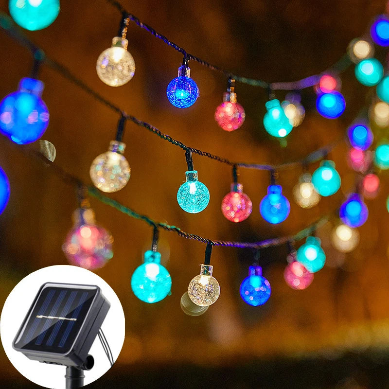 String lights with colorful LED orbs hanging in the dark outdoors