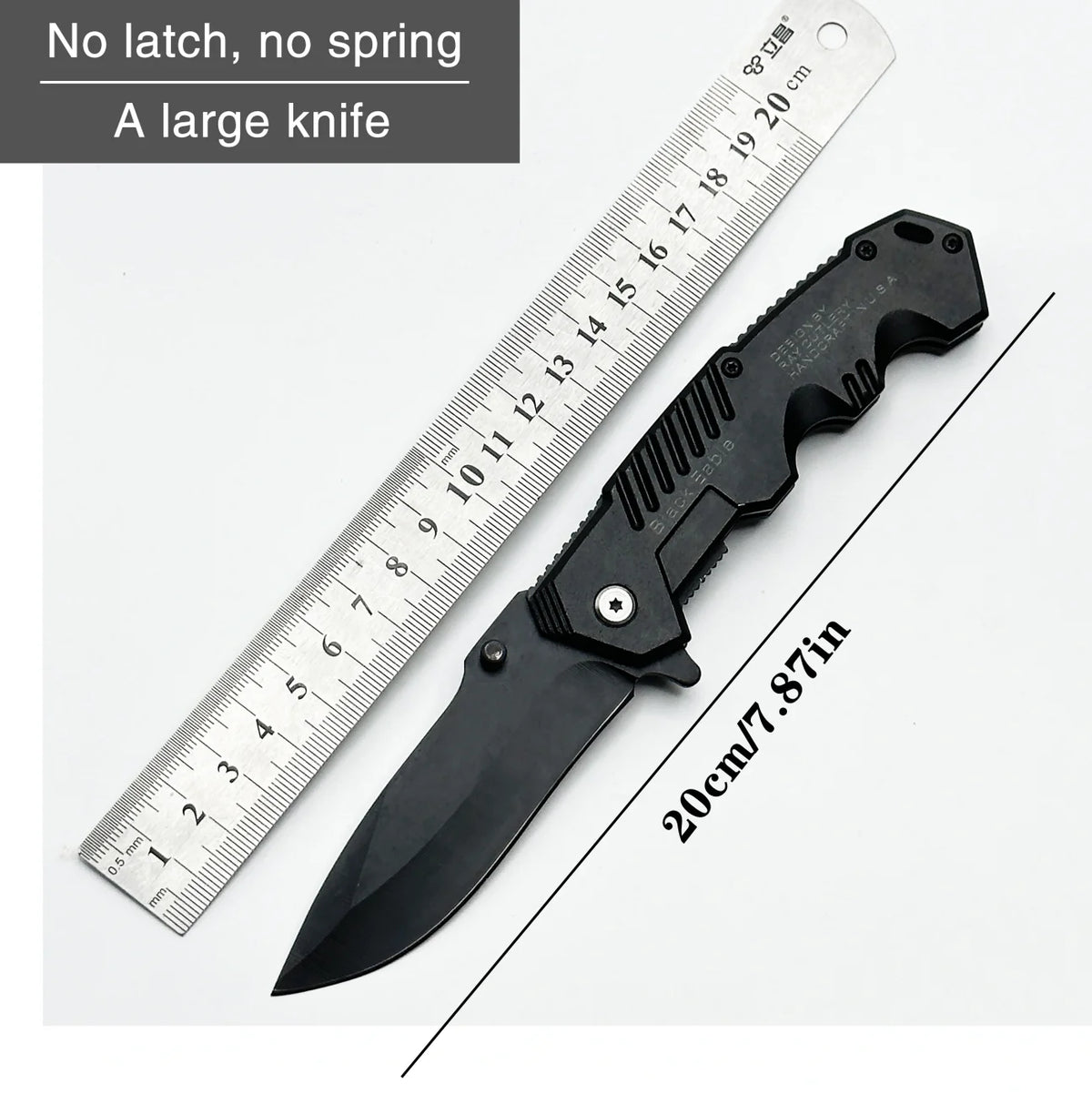 A large black folding survival knife shown next to a ruler for scale.