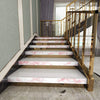 Treppe mit rosa Marmortreppen und goldenen Geländern in einem modernen Innenraum.