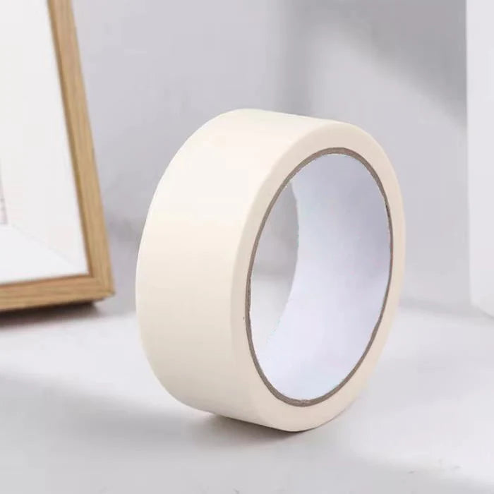 A roll of white painter's tape used for masking trim and grout.