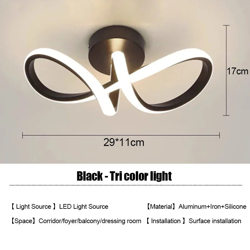 Lámpara de tres colores negro con diseño moderno y curvo, montada para instalación en superficie.