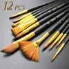 A set of twelve black nylon flat brushes with gold ferrules laid out on a dark surface.