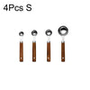 Four stainless steel measuring spoons with wooden handles.