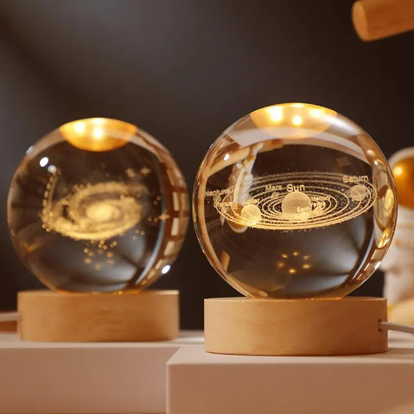 A glass crystal ball night light featuring a solar system model of Mars, Sun, and Saturn on a wooden base.