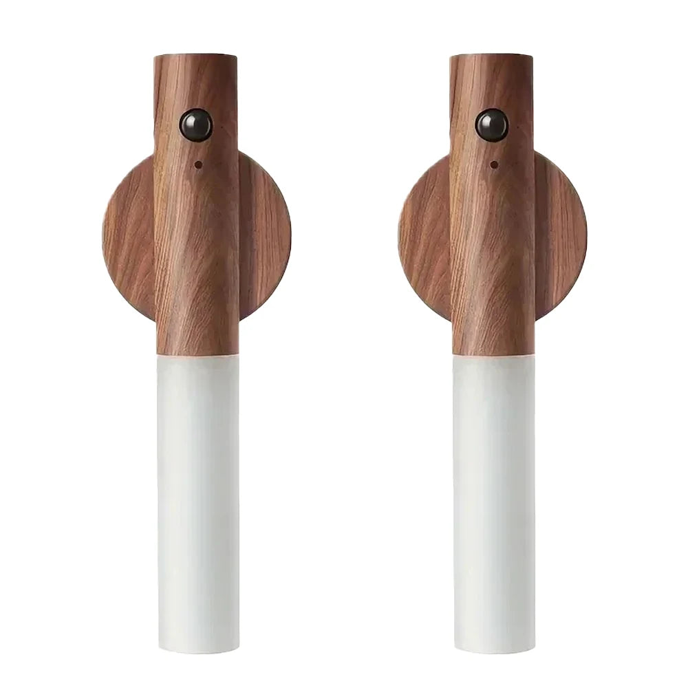 Un par de luces nocturnas LED con sensor de movimiento de madera, bases blancas y lentes negros.