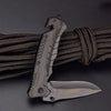 A black outdoor folding utility knife is shown attached to a black paracord strap.