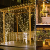 Vertikale Lichter beleuchten eine Holzterrasse und einen Garten mit warm leuchtenden Lichterketten.