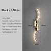 A black modern LED wall sconce with a curved design mounted on a light gray wall.