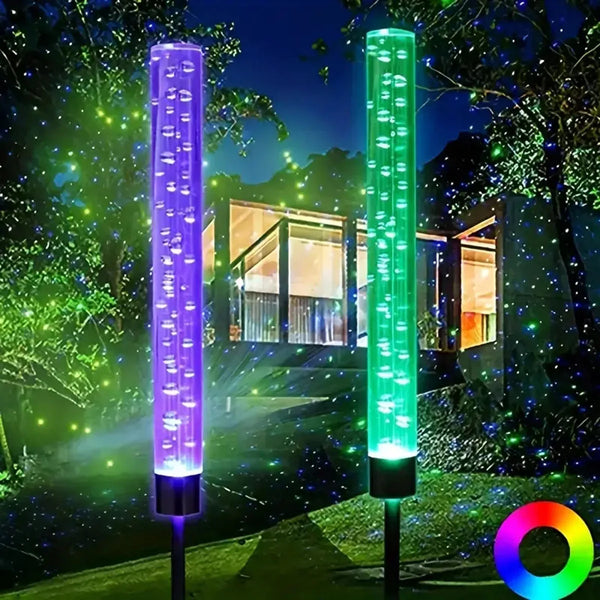 Two vertical LED bar landscape lights illuminate a garden path with glowing green and purple lights.
