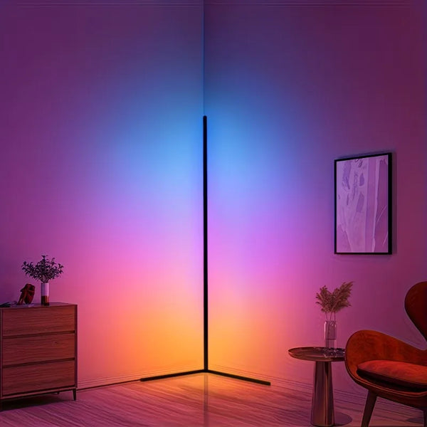 A modern interior features a tall, vertical RGB LED floor lamp casting vibrant purple and blue light onto a wall.