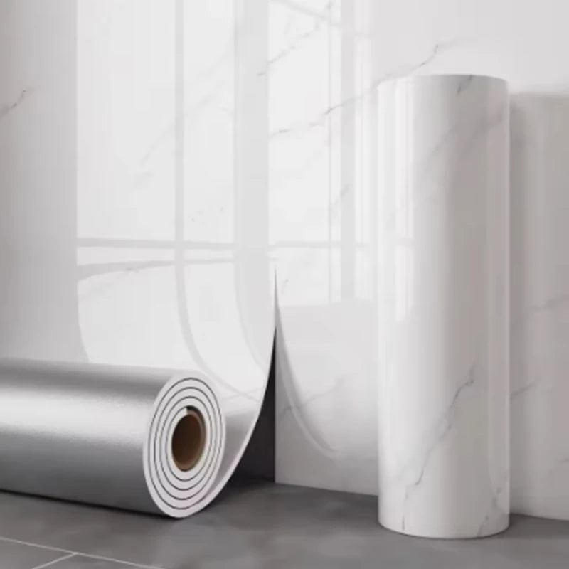 Rouleau cylindrique blanc d'autocollants imitation marbre adhésifs pour murs sur fond gris clair.