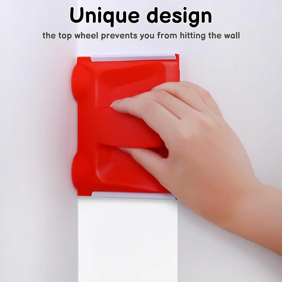 A hand is using a red precision paint edger tool to trim a corner on a white wall.