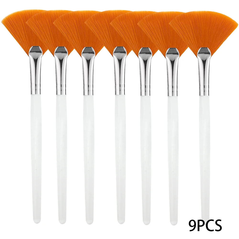 Un jeu de neuf brosses pour masques faciaux vegans oranges avec poignées argentées.