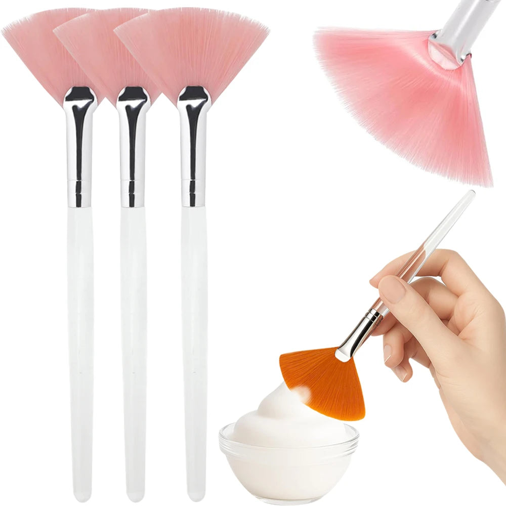 Un set de trois brosses de masque facial en silicone rose avec poignées argentées et une brosse applicatrice orange