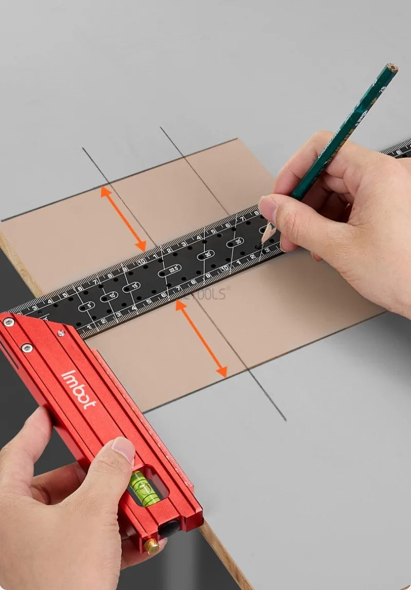 A hand holds a red Imbot measuring ruler against a wooden board, demonstrating precision measurement.