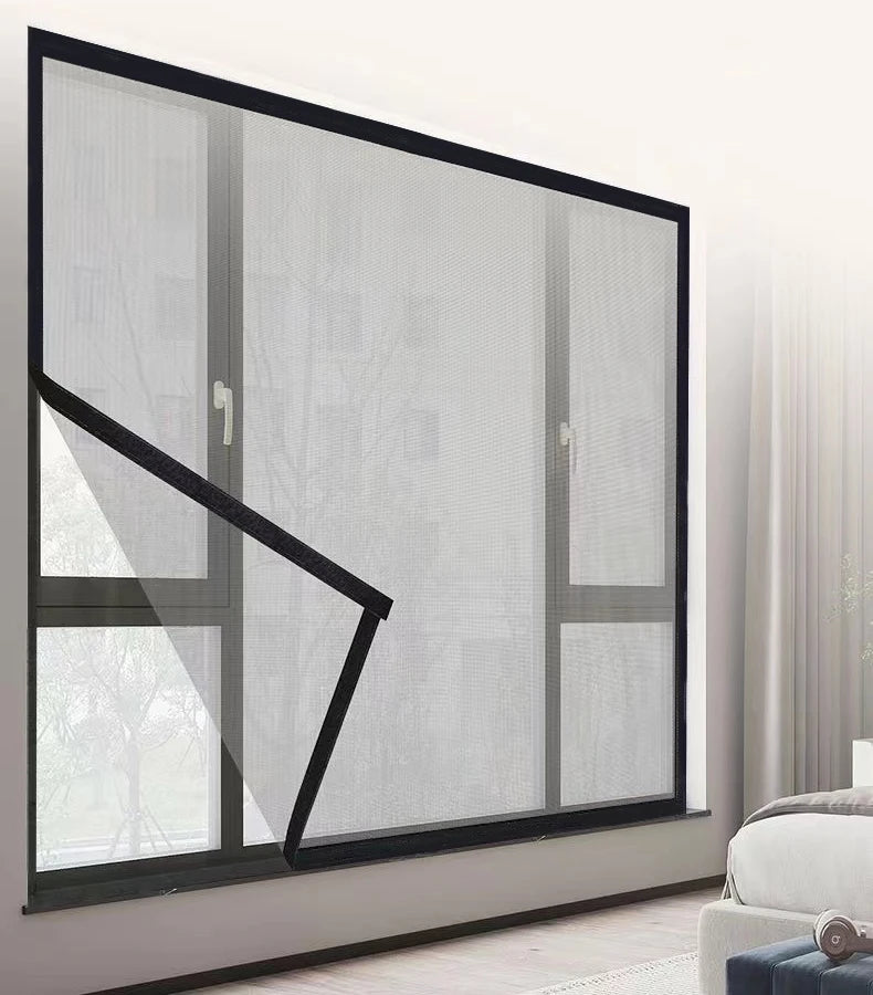 Una moderna malla de ventana negra instalada en un marco gris en una pared.