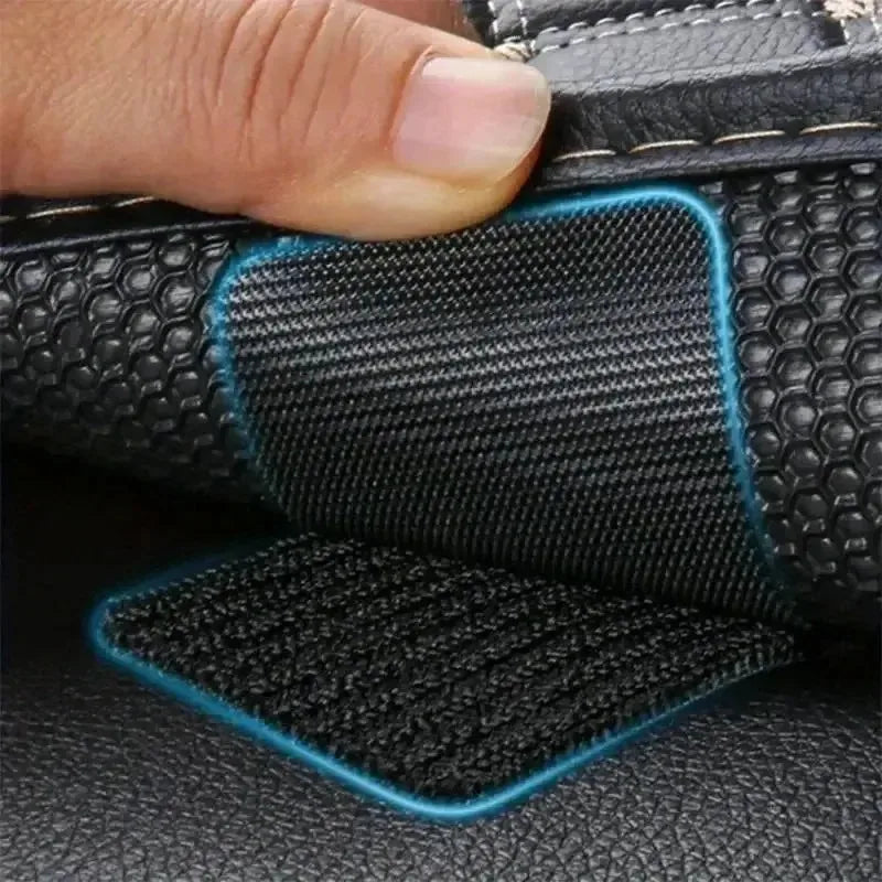 Close-up of black hook and loop carpet fixing tape being applied to a black leather surface.