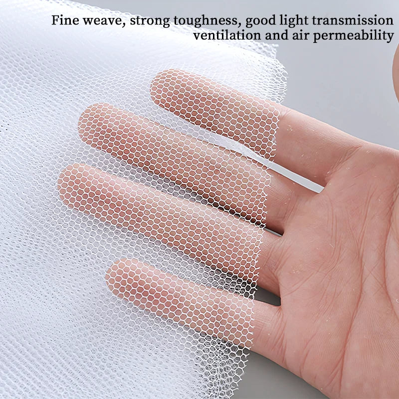 A hand is holding a piece of fine mesh window screen material, demonstrating its weave and light transmission.