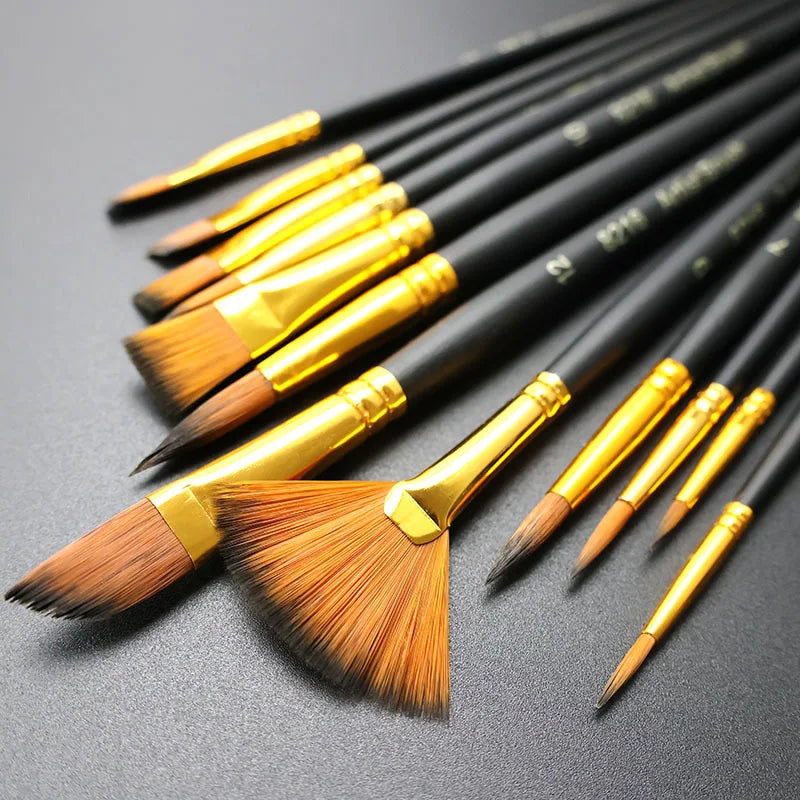 A set of twelve black nylon flat painting brushes with gold ferrules arranged diagonally on a dark surface.