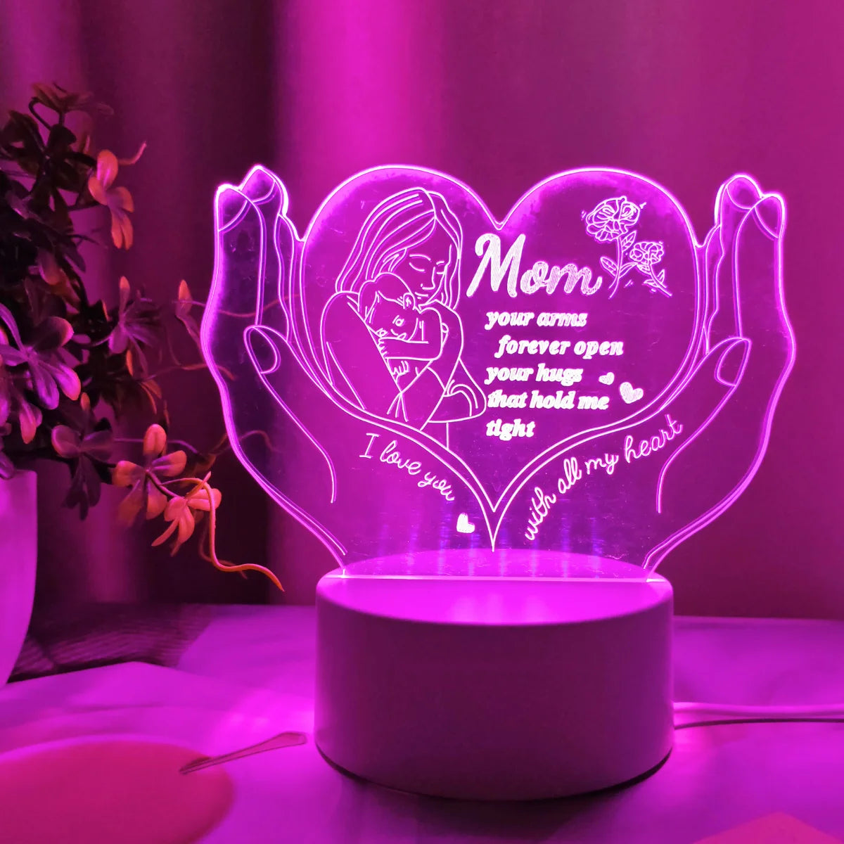 A glowing heart-shaped night light featuring a silhouette of a mother and child, set against a purple background.