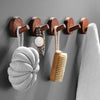 Rustic wooden wall hooks displaying various natural fiber and wooden items like a brush and a knitted ball