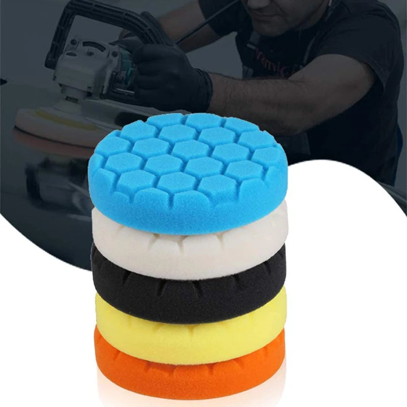 A stack of five compound buffing polishing pads in blue, white, black, yellow, and orange for auto detailing.