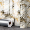 Goldfolien-Marmor-Roll mit selbstklebenden Wandaufklebern neben einer marmorierten Wand.