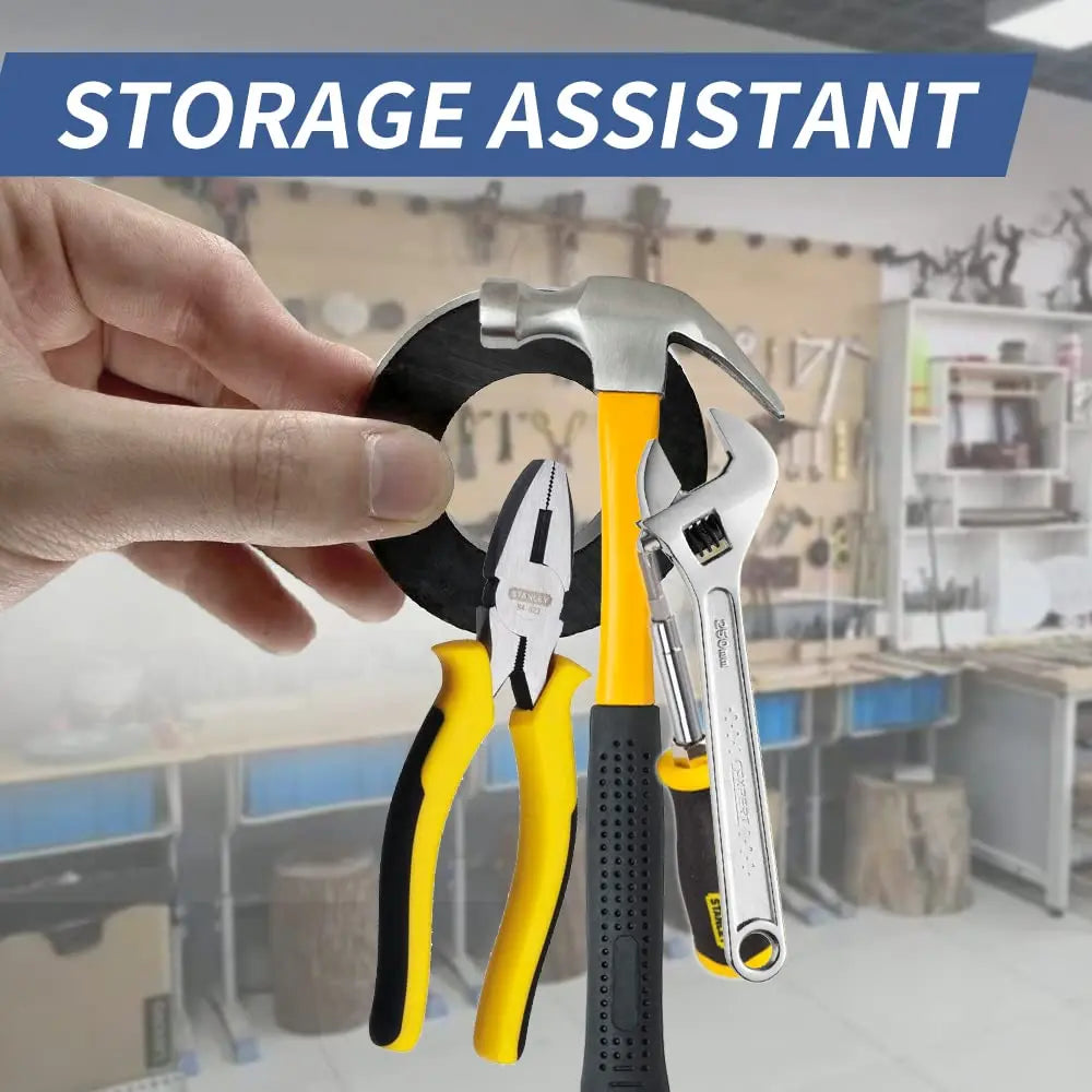 A hand holds a set of industrial ceramic ring magnets, including pliers and a hammer, in a workshop setting.