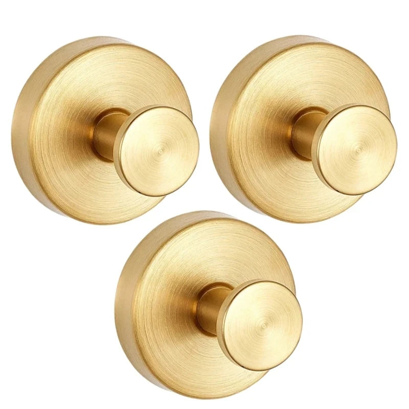 A close-up view of a round, brass-toned shower hook with a smooth finish and a circular mounting plate.