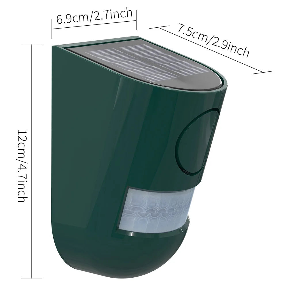 A dark green solar motion security alarm with a glass lens and a solar panel top.