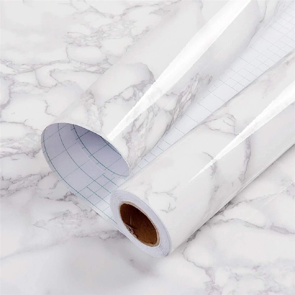 Roll of glossy pink marble contact paper lying on a white marble surface