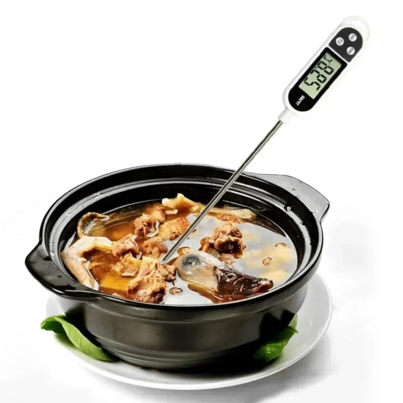 Un thermomètre alimentaire numérique inséré dans une casserole noire contenant du liquide et de la viande.