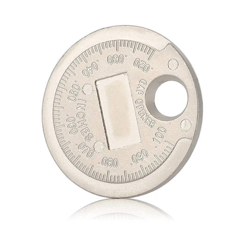 A round metal coin used for measuring spark plug gap, showing markings and an opening.