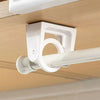 White rotating adhesive curtain rod brackets mounted on a ceiling, used to support a white curtain rod.