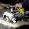 A hand is operating a silver precision diamond saw with a bright yellow handle, cutting into a tile surface.