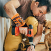 A man is using an orange magnetic wrist strap tool on a dog, demonstrating the tool for DIY and repair.
