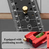 A close-up of a black precision measuring ruler with a brass positioning needle and a red tool.